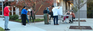 Students practice filming in front of Grady College.